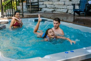 Family of four having a fun time using their swim spa