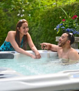 Man and woman having a chat in a luxury hot tub with flowers in the background