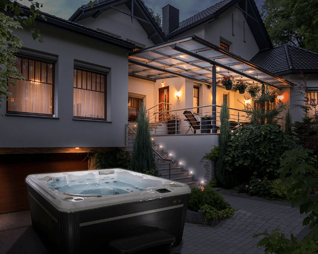 Luxury hot tub running at night time outside a big house