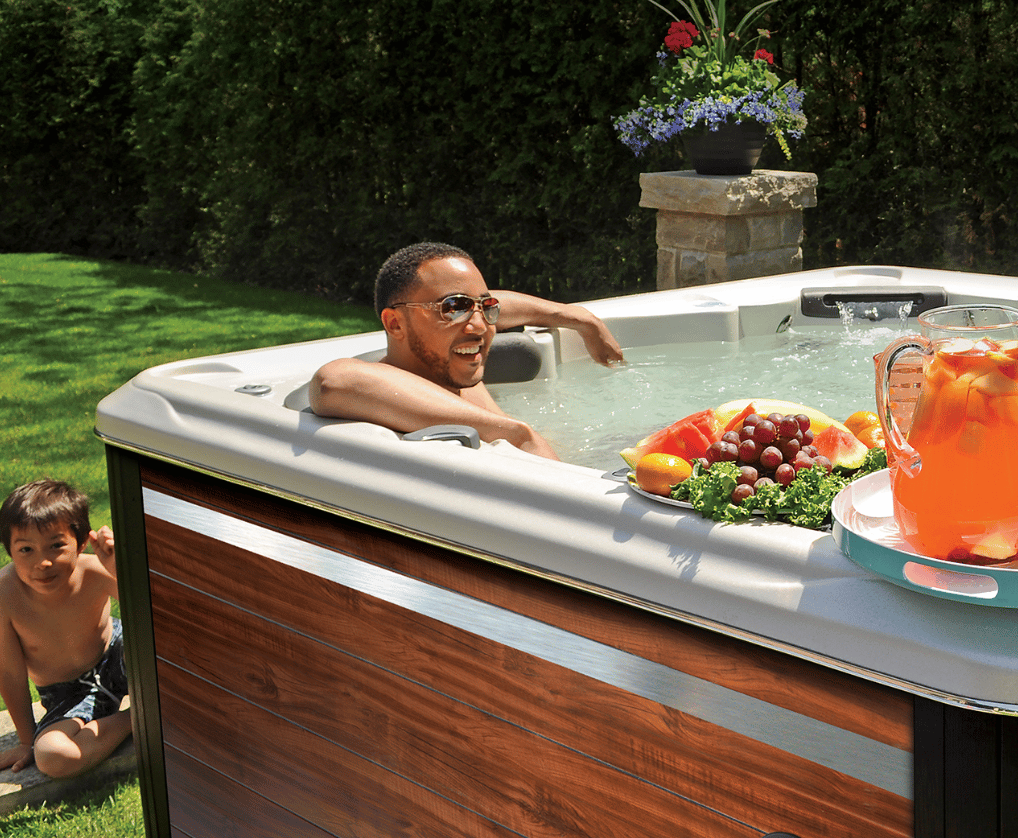 Man chilling in a hydrotherapy pool while child is smiling in the background