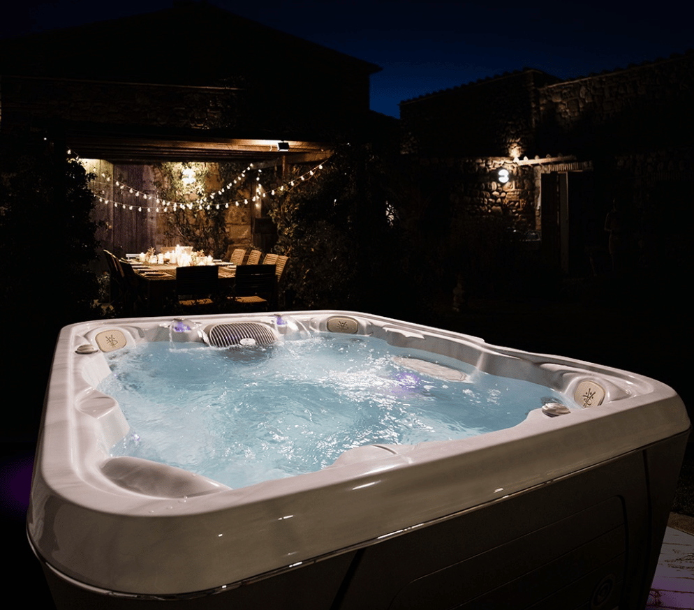 Hydrotherapy pool shining in the night next to dining table